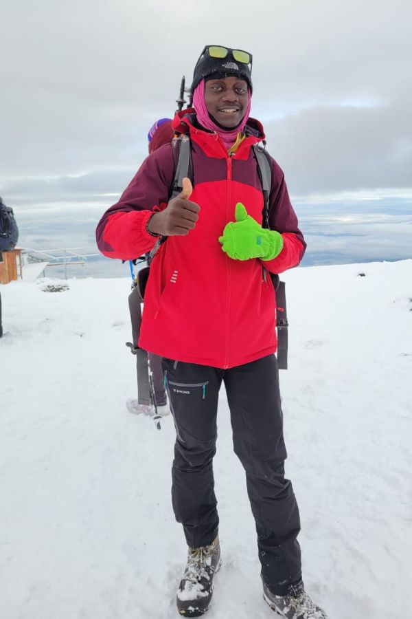 Innocent Mtei, founder of Komteshane Tanzania Safaris, at the summit of Mount Kilimanjaro